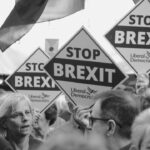 People holding "stop brexit" signs at a rally.