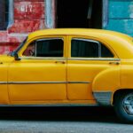 yellow sedan parked near red concrete building