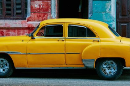 yellow sedan parked near red concrete building