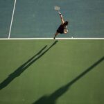 woman in black top holding tennis racket