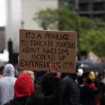 people holding brown wooden signage during daytime