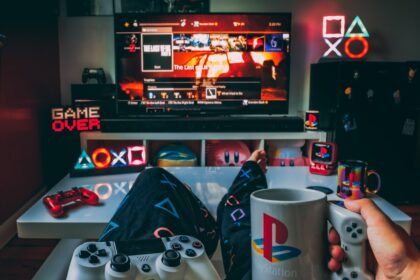 a person holding a cup and a game controller in front of a television