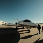 a group of people walking towards a small plane