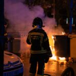 a firefighter standing in front of a fire