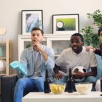 three men sitting on a couch in a living room