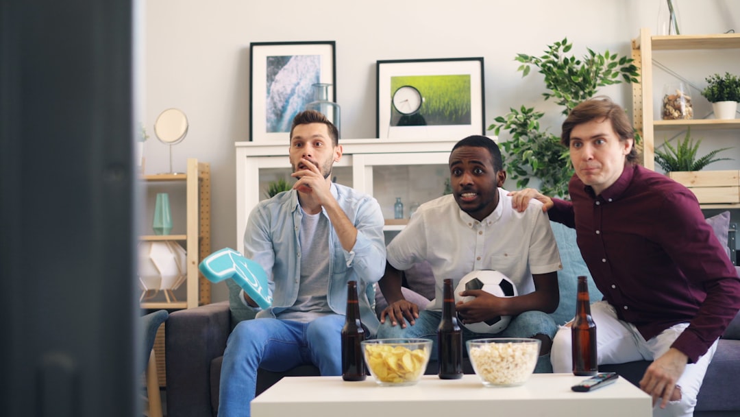 three men sitting on a couch in a living room