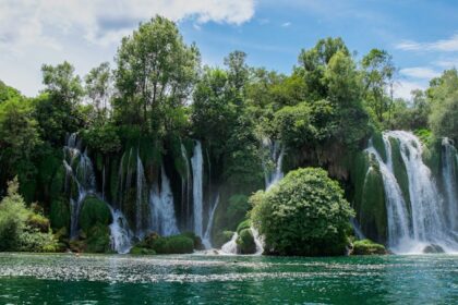 a large waterfall in the middle of a body of water
