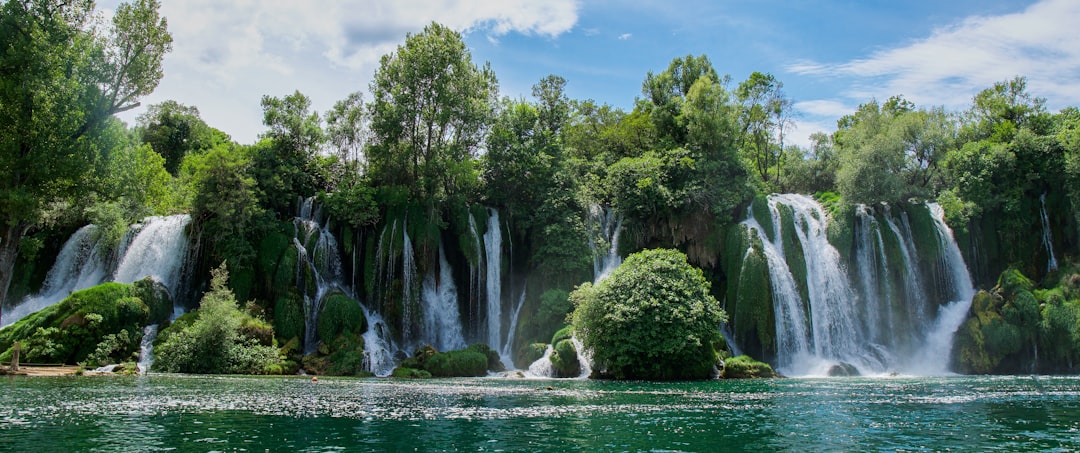 a large waterfall in the middle of a body of water