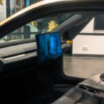 A picture of a man's face on a monitor in a car