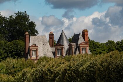 A beautiful house is nestled among lush greenery.