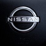 Close-up of a nissan car steering wheel logo.