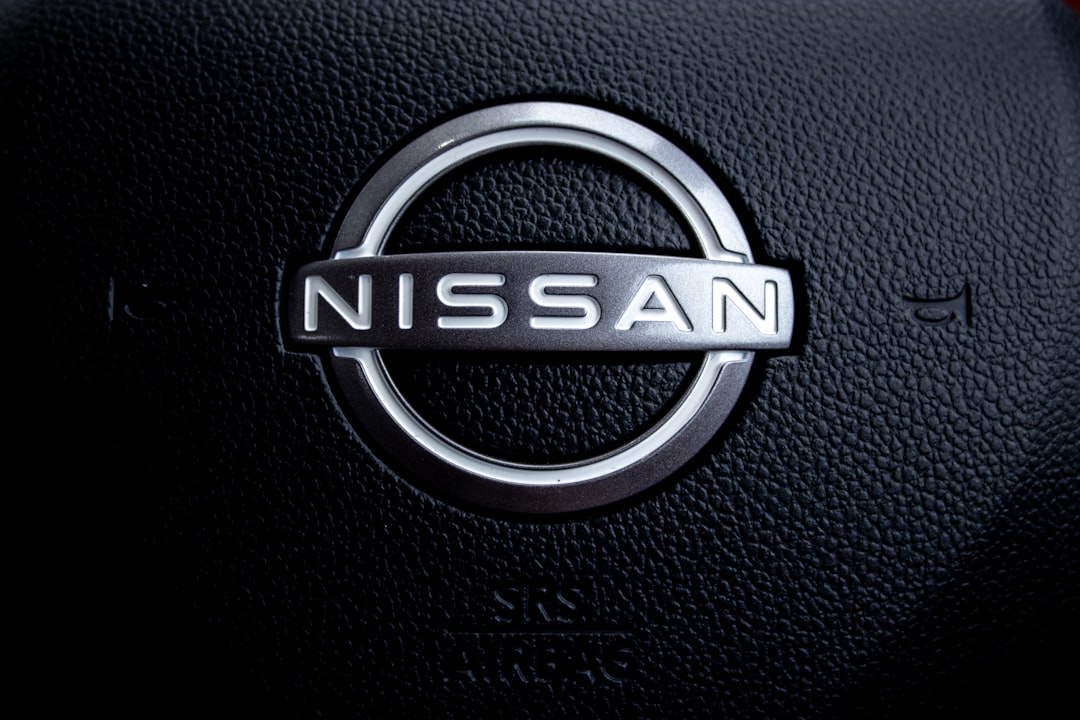 Close-up of a nissan car steering wheel logo.