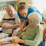 Caregiver assisting elderly couple with coloring