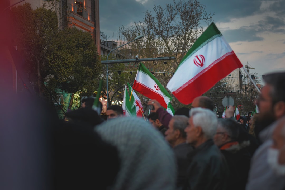 People holding iranian flags in a public gathering.
