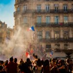 people waving flag of France near building