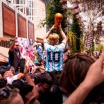 a crowd of people standing around a man holding a basketball