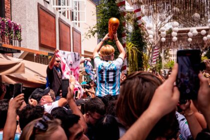 a crowd of people standing around a man holding a basketball