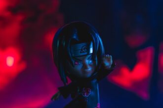 a close up of a doll with a red light in the background