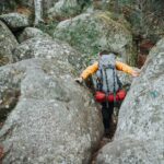 a man climbing up the side of a large rock
