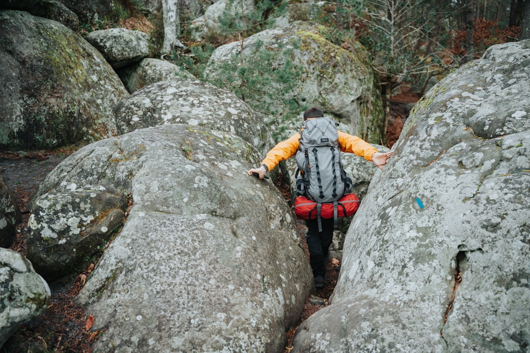 a man climbing up the side of a large rock