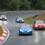 a group of cars driving down a race track