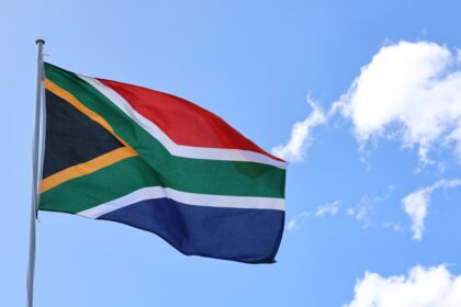 a flag flying in the wind on a sunny day