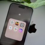 an iphone sitting on top of a table next to a leaf