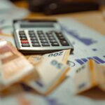 A calculator sitting on top of a pile of money