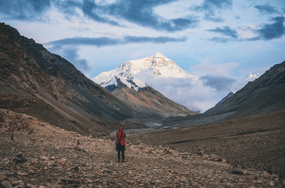 A lone hiker gazes at a snow-capped mountain
